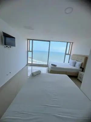 a bedroom with a bed and a view of the ocean at Pent House 450 mts 360 front ocean view playa azul in Cartagena de Indias