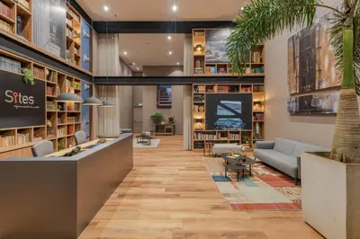 a lobby of a library with couches and a table at Hotel Sites Barranquilla in Barranquilla