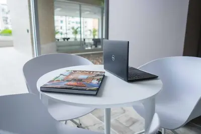 a laptop sitting on a white table with two chairs at Suite de lujo Distrito 90 in Barranquilla