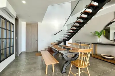 a dining room with a table and chairs and a staircase at Penthouse en zona norte cartagena luxury con 3 habitaciones y excelente wifi in Cartagena de Indias