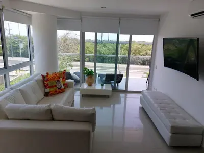 a living room with a white couch and a tv at Apartamento Morros vitri 214 zona norte in Cartagena de Indias