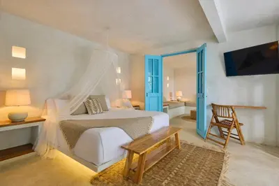 a bedroom with a bed and a table and a tv at Fenix Beach Cartagena in Tierra Bomba