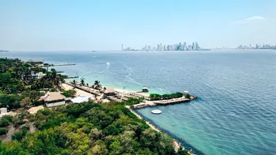 an island in the water with a city in the background at Fenix Beach Cartagena in Tierra Bomba