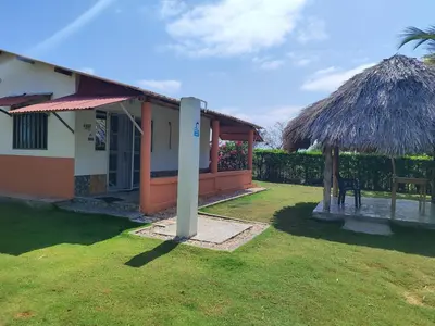 a small house with a grass umbrella and a table at El ensueño in San Bernardo del Viento