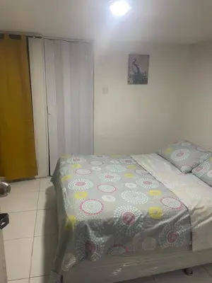 a bedroom with a bed with a flowered blanket on it at Habitación independiente cerca al mar. in Puerto Salgar