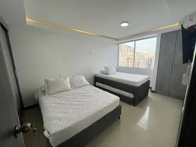 a small bedroom with two beds and a window at Apartamento Vacacional Cartagena in Cartagena de Indias