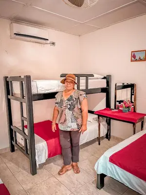 a woman standing in a room with two bunk beds at Casa Hotel Las Antillas in Tolú
