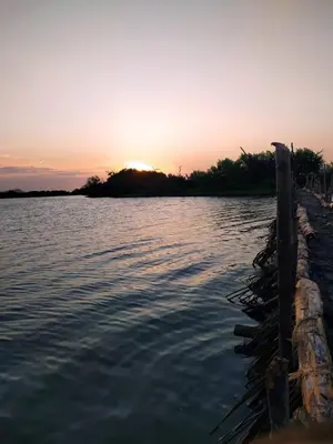 a sunset over a body of water with a dock at Cabaña El Faro in Tubará