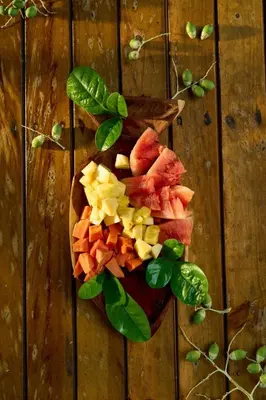 a bowl of fruit and vegetables on a wooden table at Múcura Club Hotel in Isla Mucura
