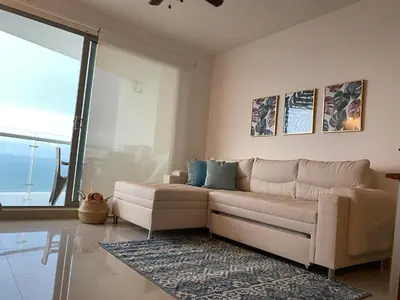 a living room with a couch and a large window at Paraíso frente al Mar Caribe en Cartagena. in Cartagena de Indias