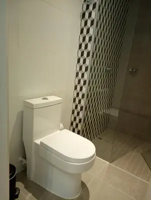 a bathroom with a white toilet and a shower at Linda suite in Barranquilla