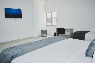 a bedroom with a bed and a tv on the wall at Hotel El Marqués De Manga in Cartagena de Indias