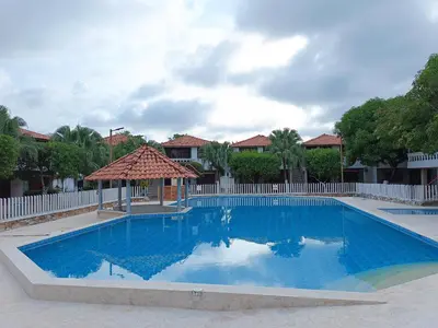 a large blue swimming pool with a white fence at Cabaña en coveñas in Coveñas