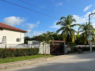 a man riding a bike down a street with a building at Cabaña en coveñas in Coveñas