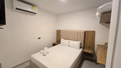 a small room with a bed with a white mattress at Oceanfront loft in high level neighborhood in Cartagena de Indias