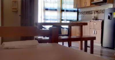 a kitchen with a table and chairs and a refrigerator at Hotel Costa Mar Coveñas in Coveñas