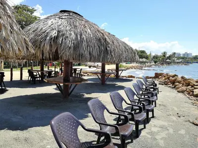 a row of chairs and tables on a beach at Hotel Costa Mar Coveñas in Coveñas