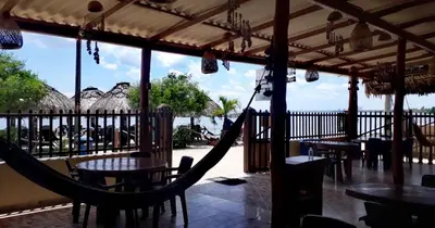 a hammock in a restaurant with a view of the beach at Hotel Costa Mar Coveñas in Coveñas