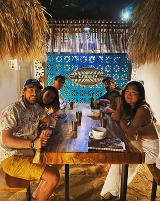a group of people sitting at a wooden table at KokohauBungalows in Santa Veronica