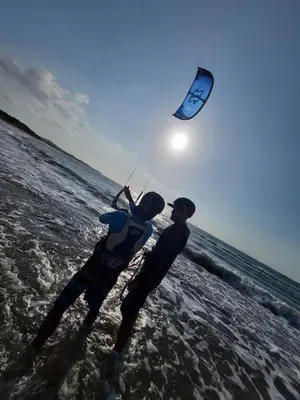 two people flying a kite on the beach at KokohauBungalows in Santa Veronica