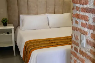 a bed in a room with a brick wall at Casa Lorenza Hotel in Cartagena de Indias