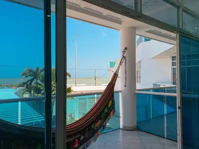 a hammock on a balcony with a view of the ocean at Hotel Abi Inn By GEH Suites in Cartagena de Indias