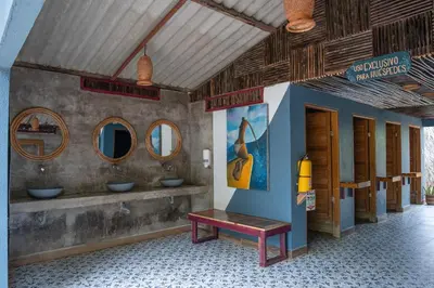 a bathroom with three sinks and a bench in a room at La Playita Isla Fuerte in Isla Fuerte