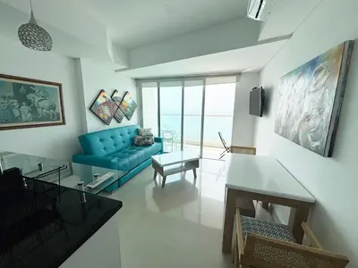 a living room with a blue couch and a table at APARTAMENTO PALMETTO ELIPTIC Bocagrande in Cartagena de Indias