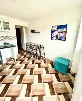 a living room with a wooden floor and chairs at Apartamentos Rincón Garcia in Cartagena de Indias