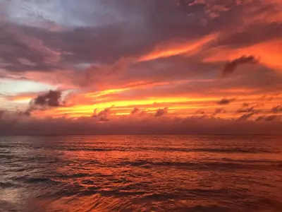 a sunset over the ocean with a cloudy sky at Hotel Villa Mary Apartaestudios playa in Puerto Colombia