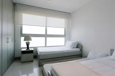 a white room with two beds and a window at Laurdhomes Lujoso Apto Piso 28 frente al mar, 2BTH in Cartagena de Indias