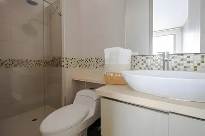 a white bathroom with a sink and a toilet at Laurdhomes Lujoso Apto Piso 28 frente al mar, 2BTH in Cartagena de Indias