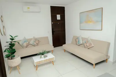 a living room with two couches and a table at Hermoso apartamento. Cerca del mar. in Santa Marta