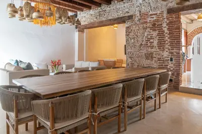 a dining room with a large wooden table and chairs at Hotel Voilá Getsemaní in Cartagena de Indias