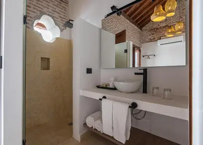 a white bathroom with a sink and a mirror at Hotel Voilá Getsemaní in Cartagena de Indias