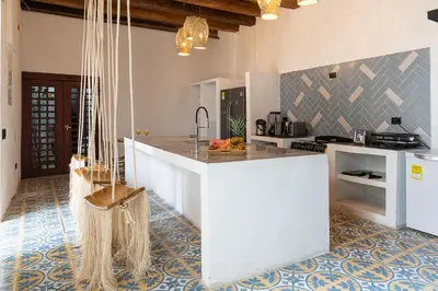 a kitchen with a white island in a room at Hotel Voilá Getsemaní in Cartagena de Indias