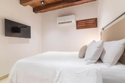 a bedroom with a white bed with white pillows at Hotel Voilá Getsemaní in Cartagena de Indias