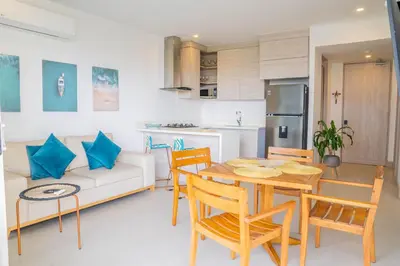 a kitchen and living room with a table and chairs at !Condominio de Lujo! Playa + Piscinas + Natural in Cartagena de Indias
