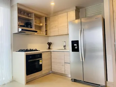 a stainless steel refrigerator in a kitchen with wooden cabinets at ✰ Beach Loft ✰ Condominio de lujo ✰ in Cartagena de Indias