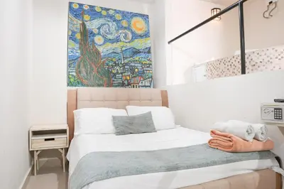 a bedroom with a bed with a painting on the wall at Casa Badillo 3 4br LUXURY ROOFTOP oldcity AC jacuzzi hottub wifi in Cartagena de Indias