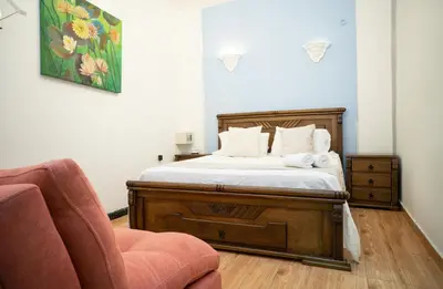 a bedroom with a bed and a chair at Casa Quero 915 4BR House Old City rooftop jacuzzi AC full Wifi in Cartagena de Indias