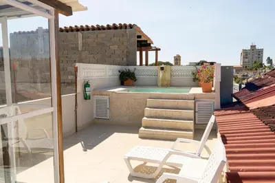 a balcony with a chair and a swimming pool at Casa Quero 954 COZY HOUSE ROOFTOP POOL AC OLD CITY in Cartagena de Indias