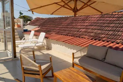 a patio with chairs and a couch and an umbrella at Casa Quero 954 COZY HOUSE ROOFTOP POOL AC OLD CITY in Cartagena de Indias