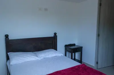 a bedroom with a bed with a wooden headboard and a table at Apartasol Amoblado Primer Piso Coveñas in Coveñas