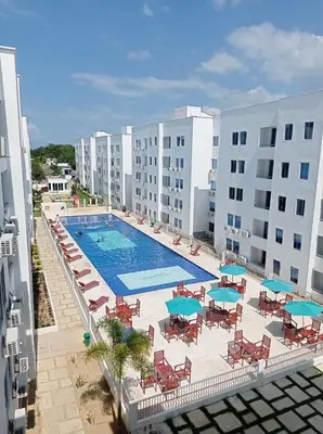 an overhead view of a swimming pool with chairs and umbrellas at Apartasol Amoblado Primer Piso Coveñas in Coveñas