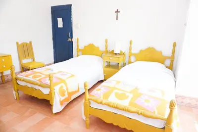 a bedroom with two beds and a chair at Casa Antigua in San Silvestre