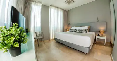 a bedroom with a bed and a potted plant at Oz Hotel Cartagena in Cartagena de Indias