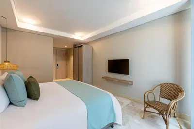 a bedroom with a large bed and a chair at Oz Hotel Cartagena in Cartagena de Indias