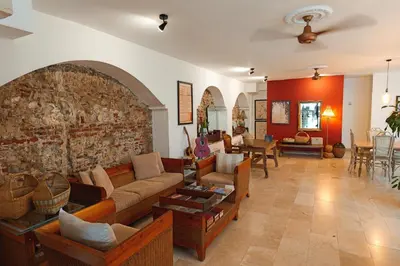 a living room with couches and a stone wall at Hotel Kartaxa in Cartagena de Indias