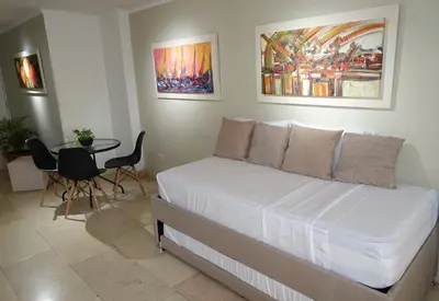 a bedroom with a bed and a table with chairs at Cabrero Beach 1111 in Cartagena de Indias